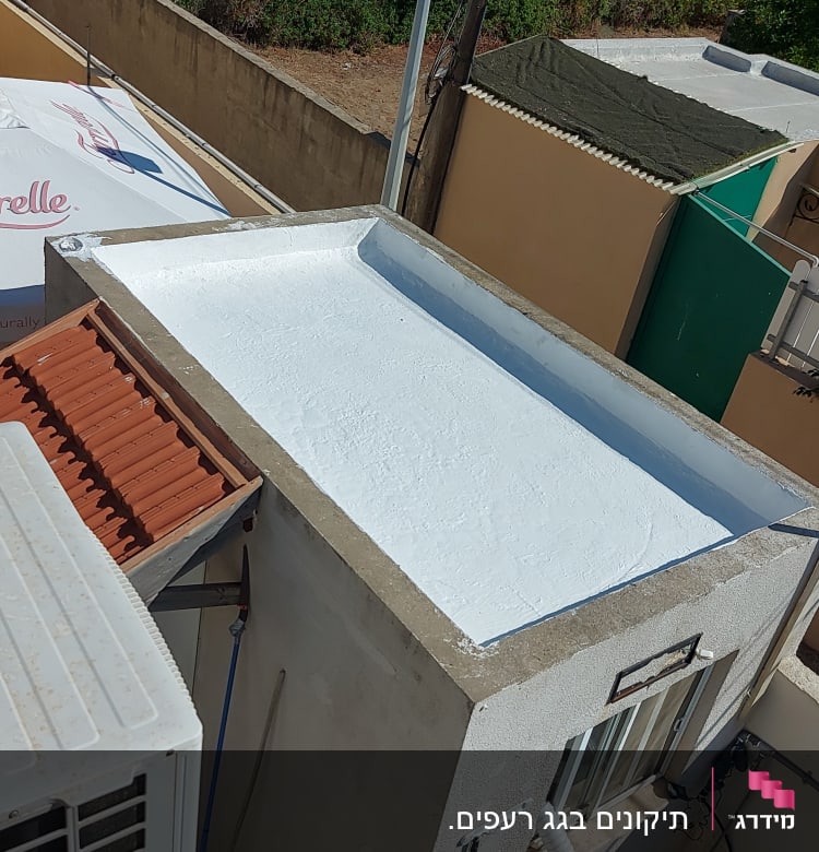 גג שטוח צבוע בלבן עם מסגרת בטון